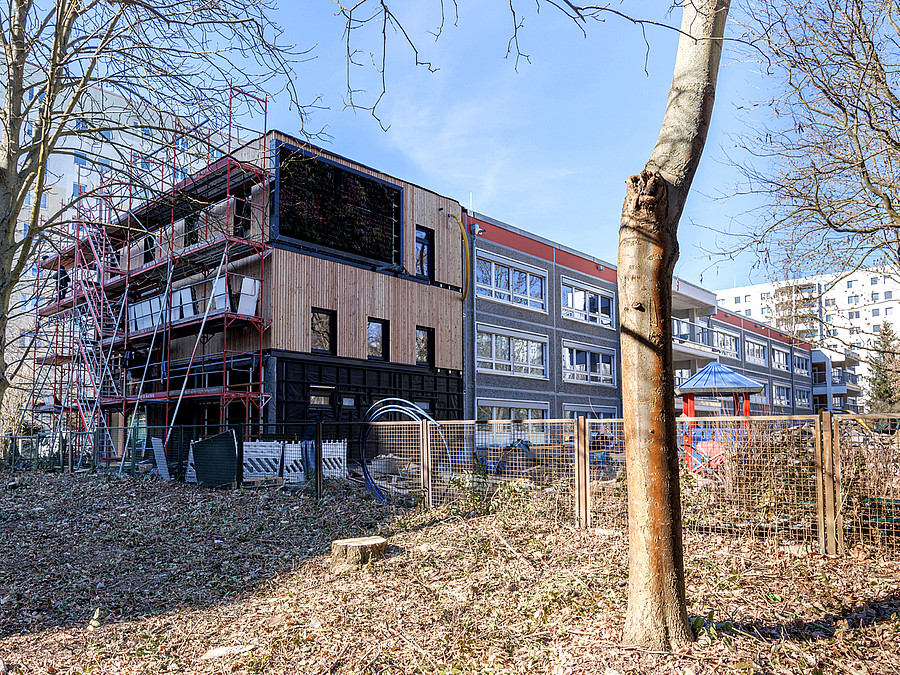Baustelle mit Holzanbau an Kita-Typenbau
