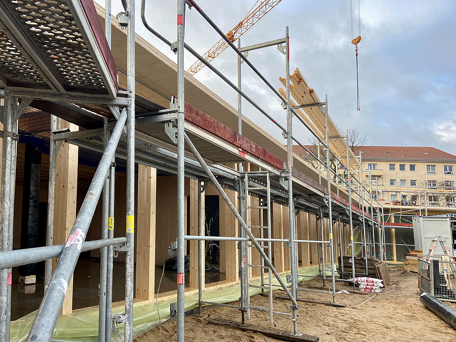 Baustelle mit Gerüst und Holzpfeilern