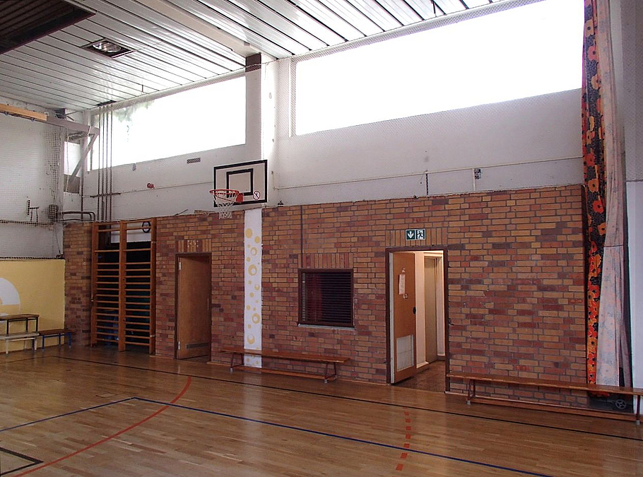 Innenraum Sporthalle mit Backsteinwand, Parkett