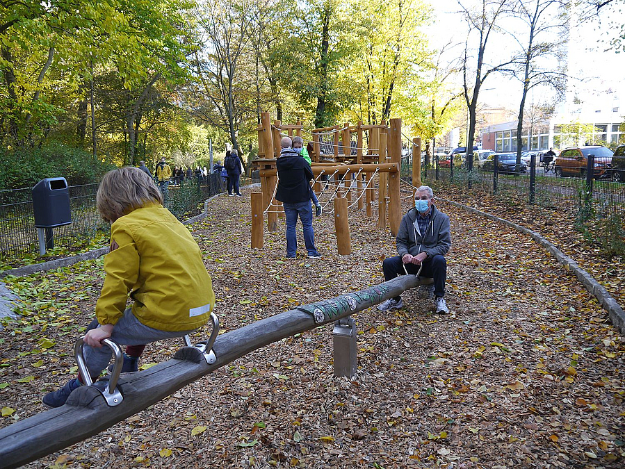 Wippe mit älterem Mann und Jungen (von hinten)