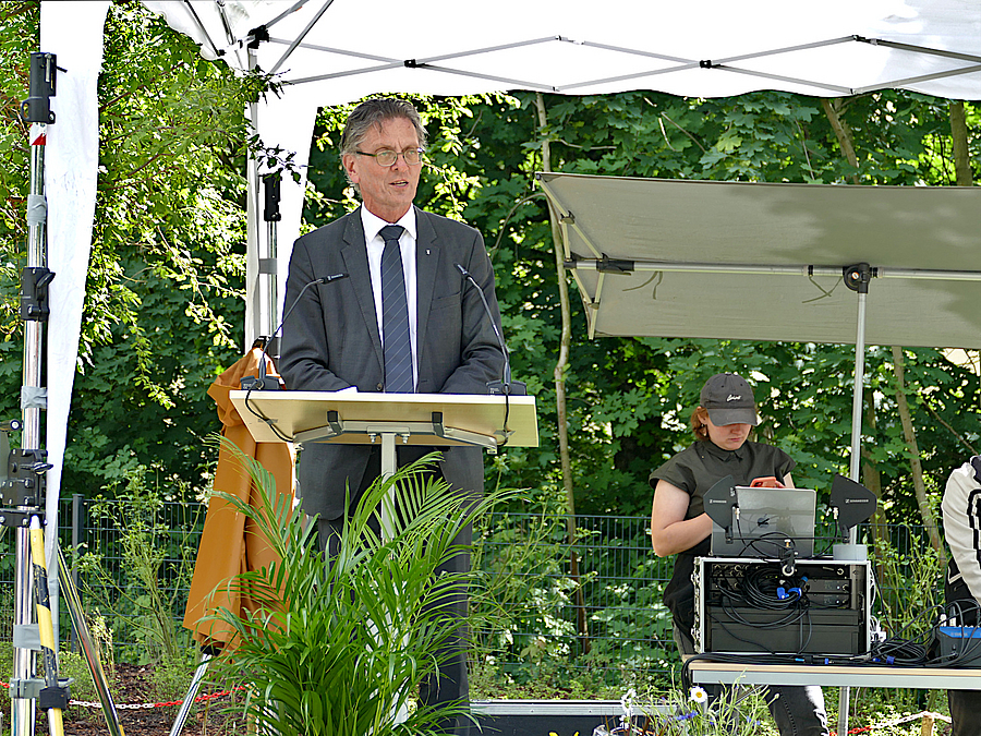 Person am Rednerpult im Freien