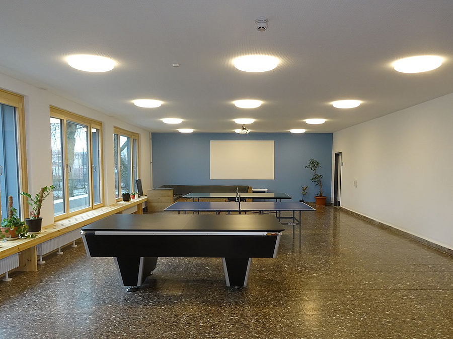 Der offene Bereich wird im Winter vor allem zum Sporttreiben genutzt Großer Raum mit neuen Deckenleuchten, breiten Fensterbrettern, 2 Tischtennisplatten, Billardtisch