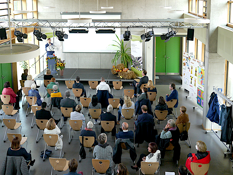 Voller Saal mit Bühne von schräg oben