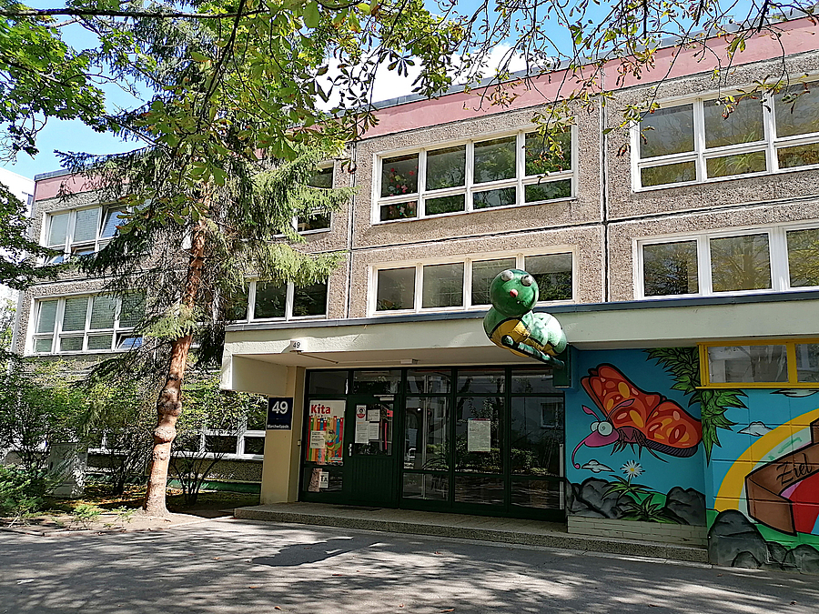 Eingang dreigeschossige Plattenbaukita mit buntem Wandbild