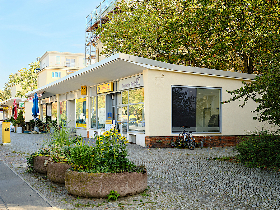 Flachbau, davor große Pflanzschalen