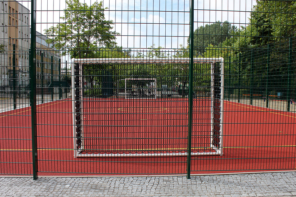 Der neue Ballspielplatz auf dem nordwestlichen Schulhof Bolzplatz mit Ballfangzaun und Fußballtoren