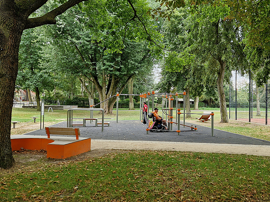 Juli 2024 Calisthenics-Anlage im Grünen mit zwei Trainierenden, einer davon im Rollstuhl