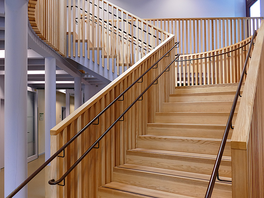 Holztreppe in violett gestrichenem Foyer