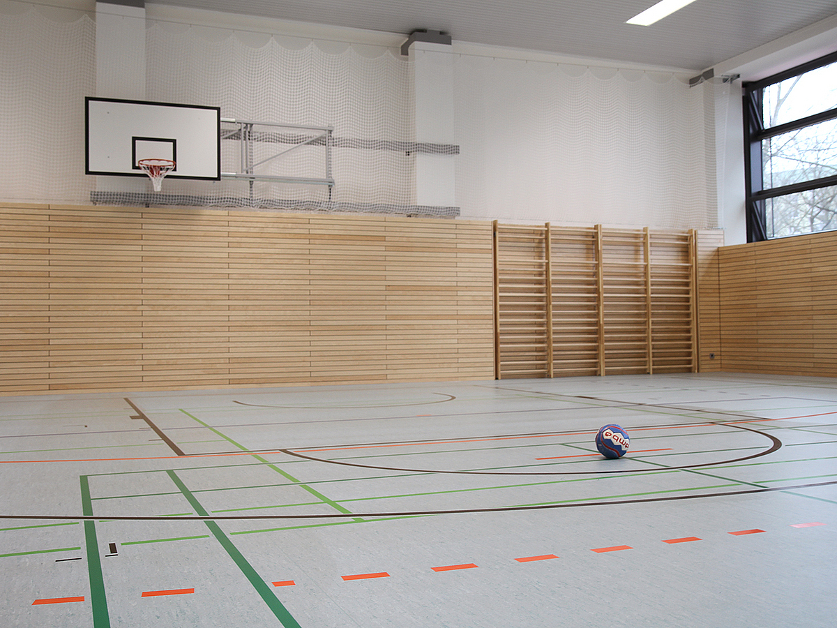Sporthale mit hellem Boden und Wandpaneelen