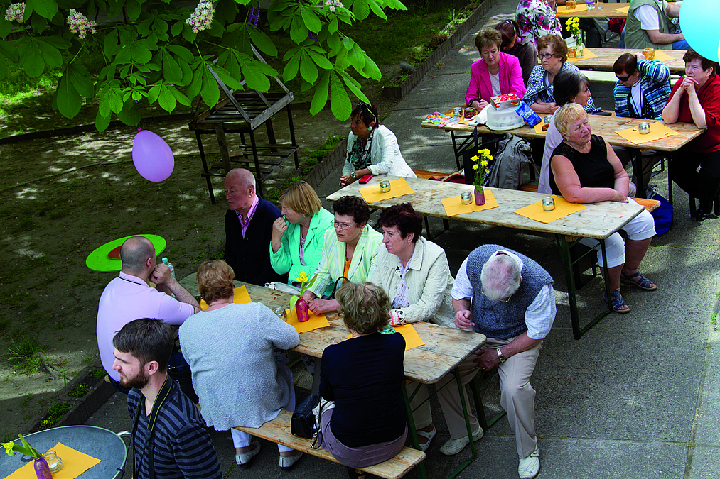 Gäste an geschmückten Tischen im Garten