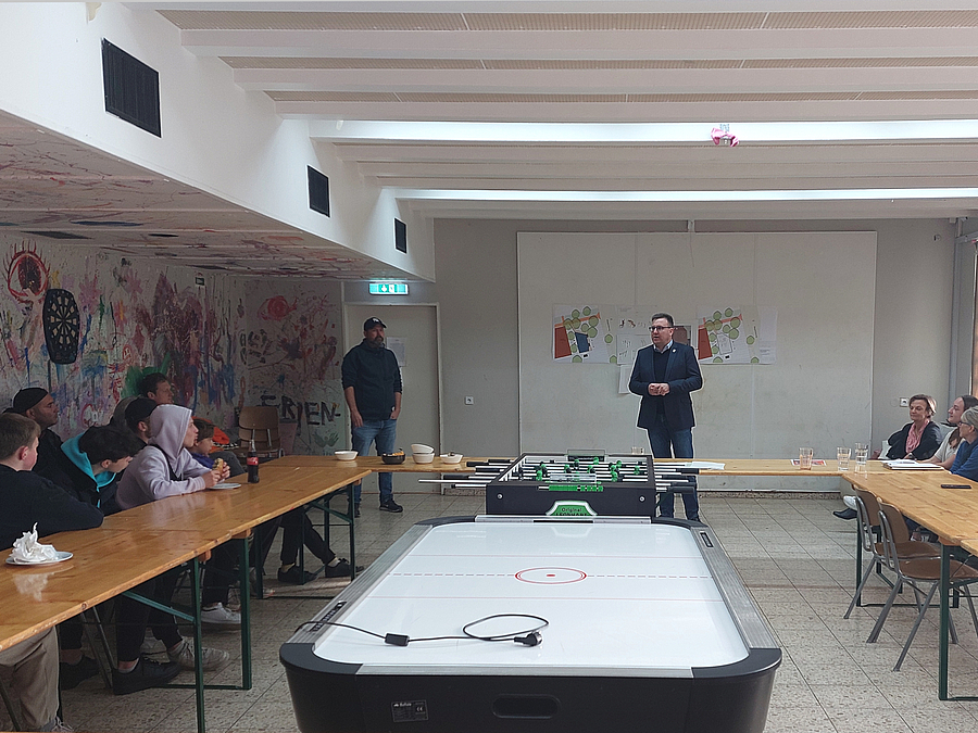 Baustadtrat Thorsten Schatz eröffnet die Präsentation vor Ort U-förmige Anordnung von Tischen, Jugendliche, Redner