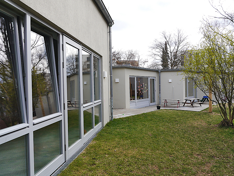 weißer Flachbau mit bodentiefen Fenstern, vor- und zurückspringende Bauteile