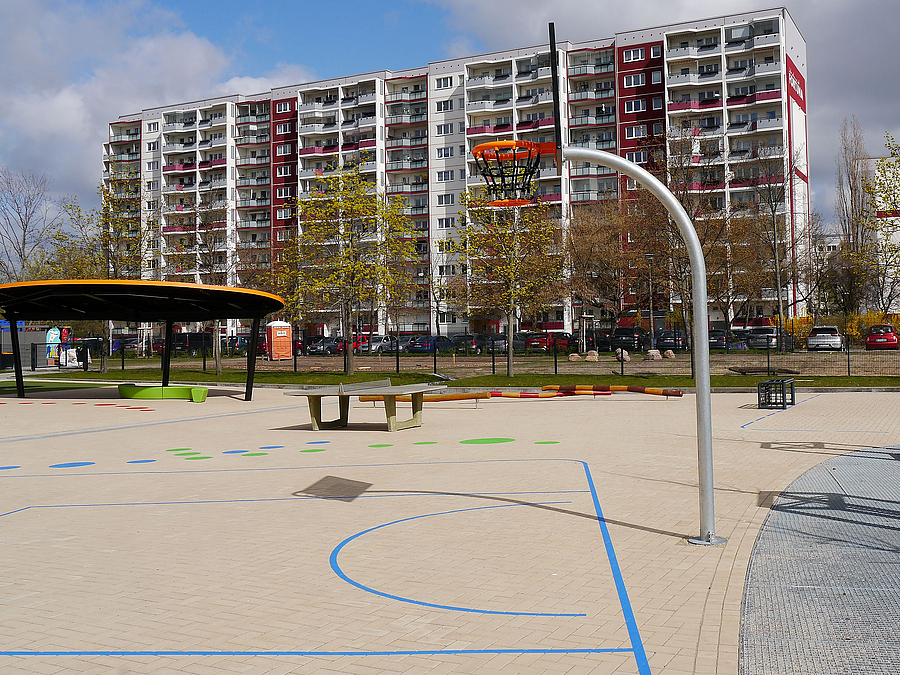 Gepflasterter Schulhof mit farbigen Markierungen, Streetballständer