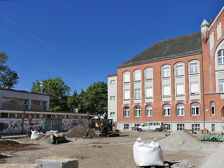 Baustelle mit Sporthalle und altem Schulgebäude