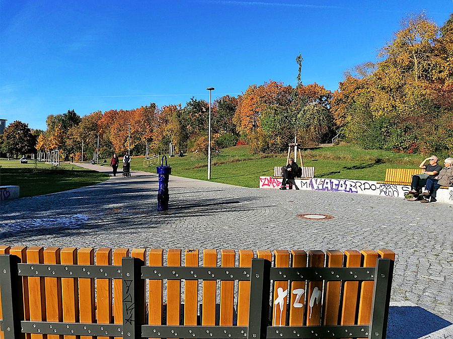 Runde Platzfläche mit Sitzmauern und Bankauflagen im Herbst