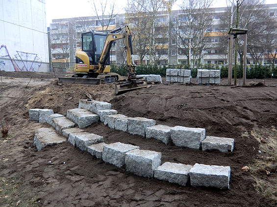 Die Sitzsteine werden als Stufen in die Böschung eingebracht