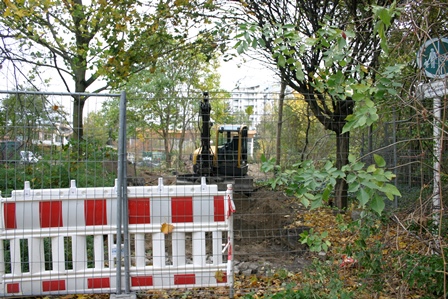 Bauzaun, dahinter Baufahrzeug
