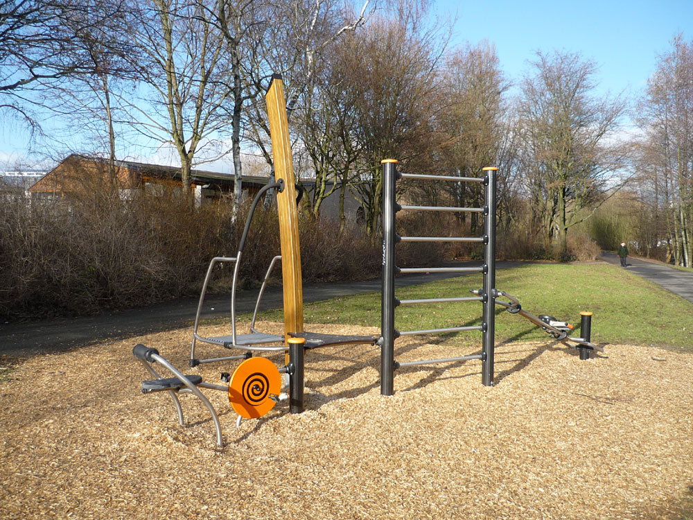 Fitnessgeräte auf Holzhäckselfläche im Park